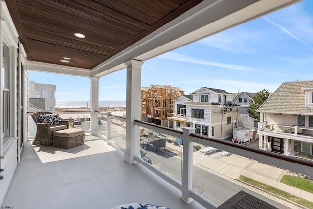 balcony featuring a beach view and a water view