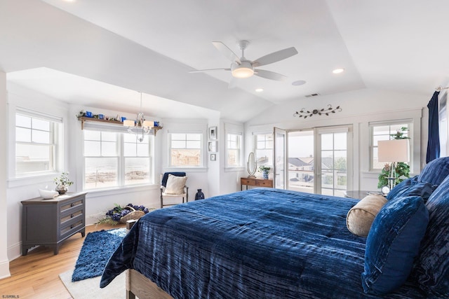 bedroom with ceiling fan with notable chandelier, lofted ceiling, and light hardwood / wood-style flooring