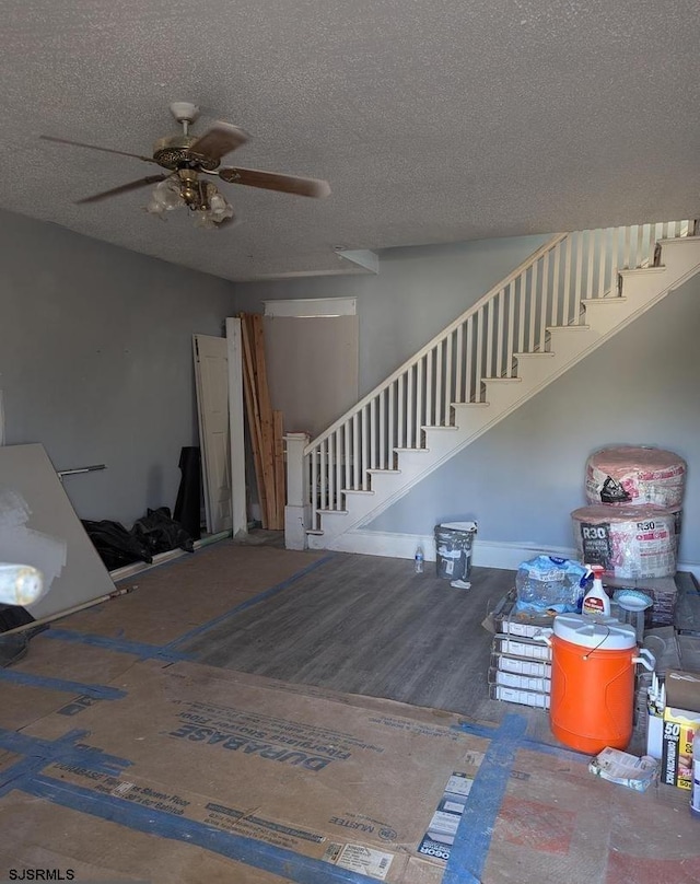 staircase featuring ceiling fan and a textured ceiling