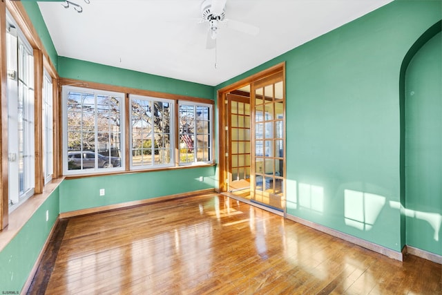 unfurnished sunroom featuring ceiling fan