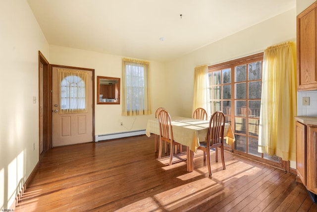 dining room with hardwood / wood-style floors and baseboard heating