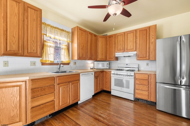 kitchen featuring ceiling fan, sink, dark wood-type flooring, tasteful backsplash, and white appliances