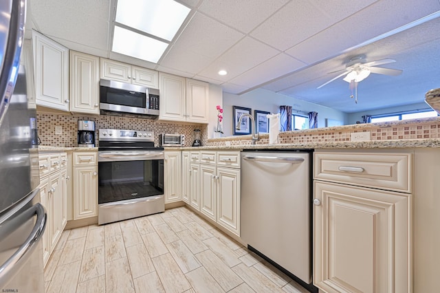 4540 W Brigantine Ave Unit N201, Brigantine, NJ 08203 - kitchen with appliances with stainless steel finishes, backsplash, ceiling fan, a paneled ceiling, and light stone countertops
