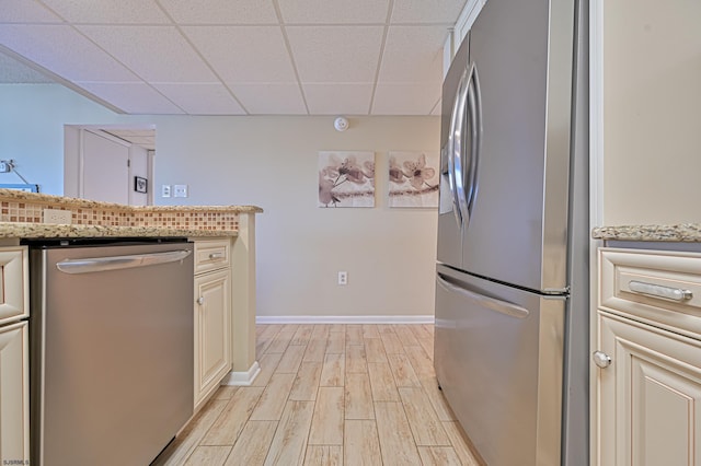 4540 W Brigantine Ave Unit N201, Brigantine, NJ 08203 - kitchen with stainless steel appliances, a drop ceiling, light wood finished floors, cream cabinets, and light stone counters