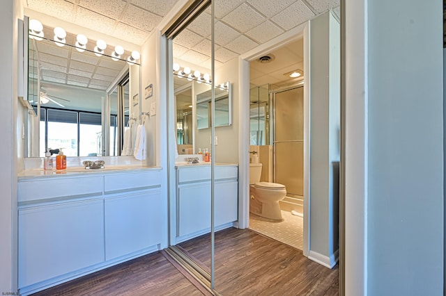 4540 W Brigantine Ave Unit N201, Brigantine, NJ 08203 - bathroom with a paneled ceiling, wood finished floors, toilet, double vanity, and a shower with door