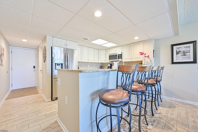 4540 W Brigantine Ave Unit N201, Brigantine, NJ 08203 - kitchen with stainless steel appliances, wood tiled floors, a peninsula, a breakfast bar area, and recessed lighting