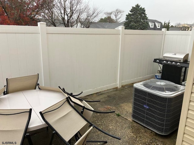 view of patio / terrace featuring central air condition unit and a grill