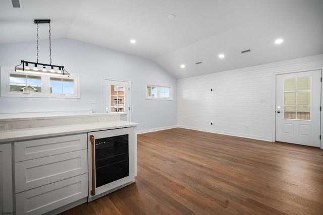 kitchen with lofted ceiling, hanging light fixtures, wine cooler, dark hardwood / wood-style floors, and gray cabinets