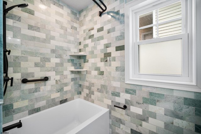 bathroom featuring shower / washtub combination and tile walls