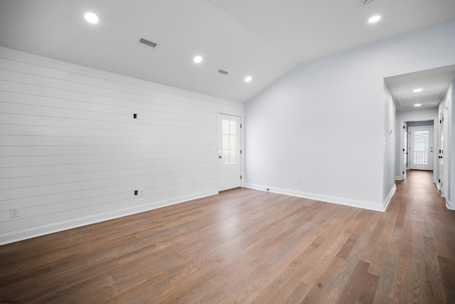 unfurnished room with hardwood / wood-style floors, a healthy amount of sunlight, and vaulted ceiling