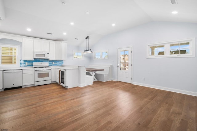 kitchen with white cabinets, wood-type flooring, white appliances, and decorative light fixtures