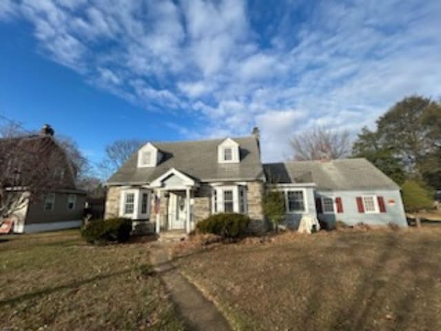 cape cod home with a front lawn