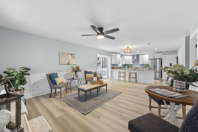 living room featuring light hardwood / wood-style flooring and ceiling fan