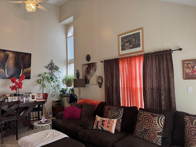 living room with ceiling fan and a towering ceiling