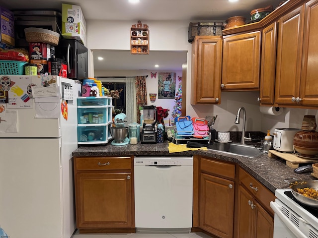 kitchen featuring sink, light tile patterned flooring, and white appliances