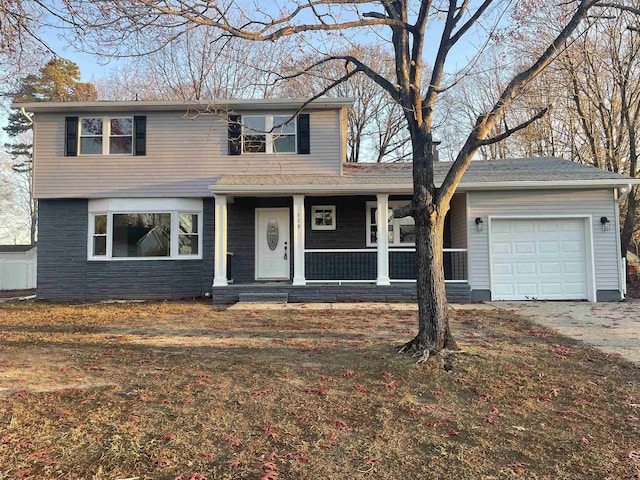 view of property with covered porch and a garage