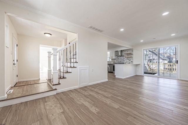 unfurnished living room featuring light hardwood / wood-style floors and crown molding