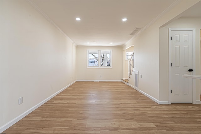 empty room featuring crown molding and light wood-type flooring