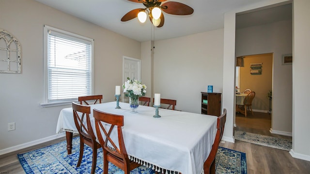 dining space with ceiling fan and dark hardwood / wood-style flooring