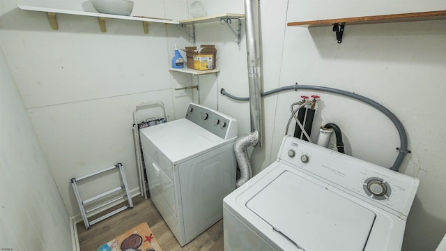 laundry room featuring wood-type flooring and washing machine and dryer