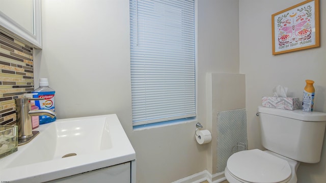 bathroom with vanity, toilet, and decorative backsplash