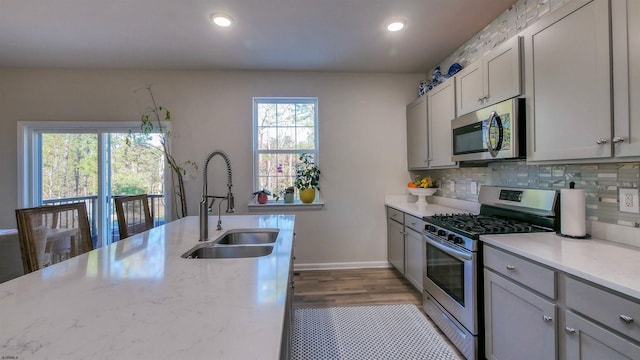 kitchen with gray cabinetry, a wealth of natural light, sink, and appliances with stainless steel finishes