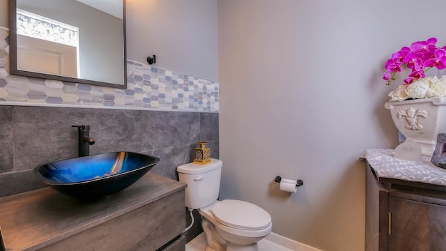 bathroom featuring vanity, tile walls, and toilet