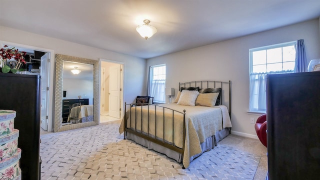 bedroom featuring light carpet and multiple windows