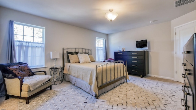 bedroom featuring multiple windows and light colored carpet