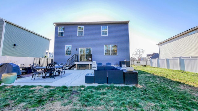 rear view of property featuring a lawn and a patio area