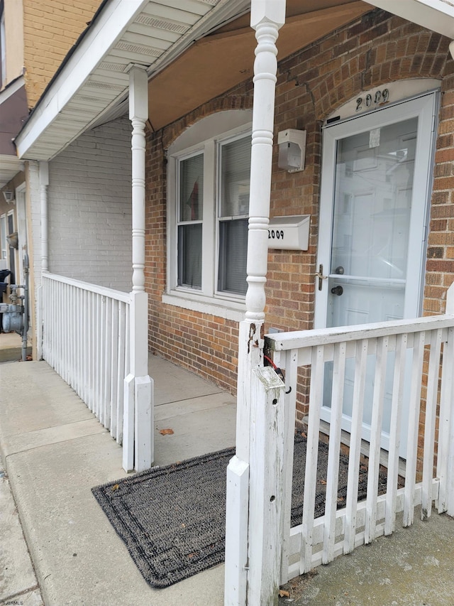 view of exterior entry featuring covered porch