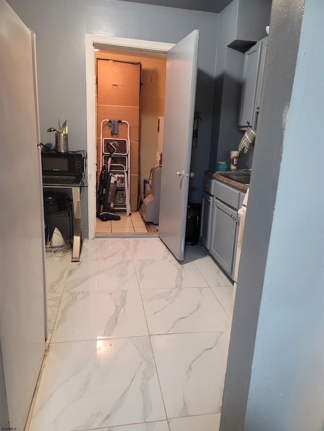 kitchen featuring white refrigerator, sink, and gray cabinetry