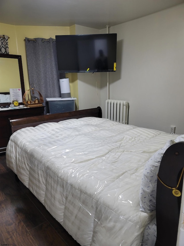 bedroom with hardwood / wood-style flooring and radiator heating unit