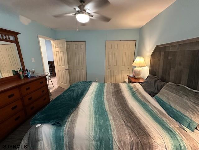 bedroom featuring ceiling fan and two closets