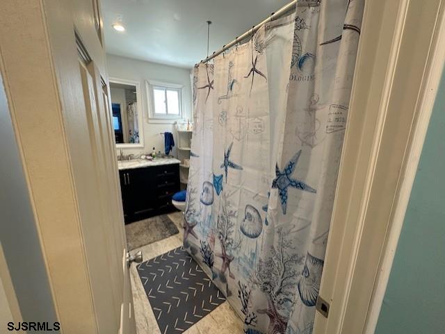 bathroom with curtained shower and vanity