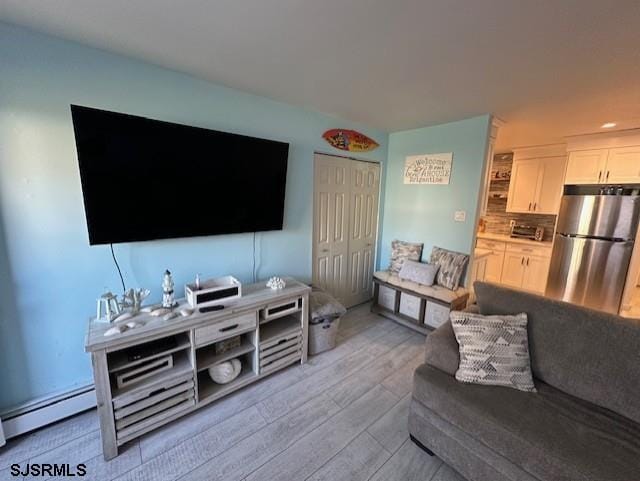 living room featuring light wood-type flooring and a baseboard radiator