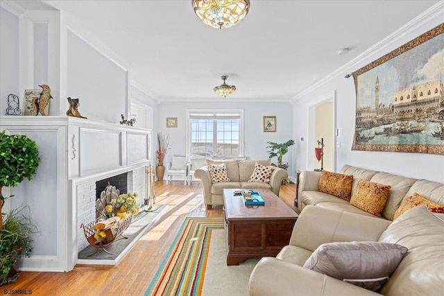 living room featuring a fireplace, light hardwood / wood-style floors, and crown molding