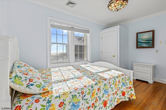 bedroom with wood-type flooring and crown molding