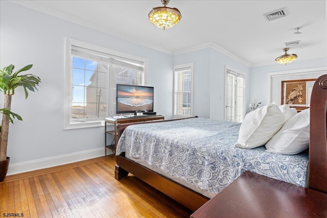 bedroom with wood-type flooring and ornamental molding