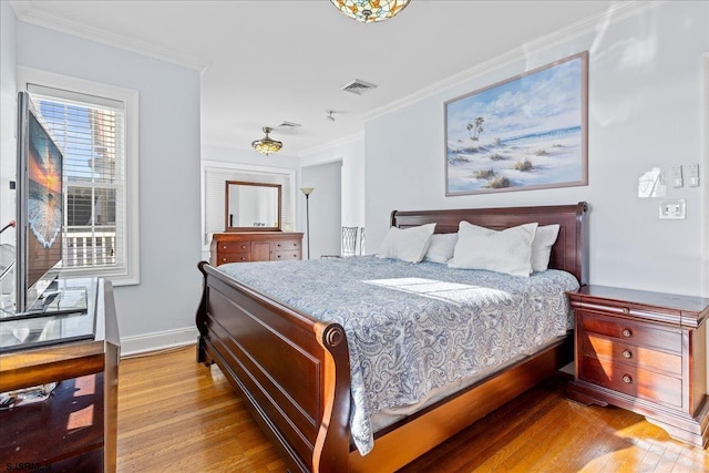 bedroom with crown molding and light hardwood / wood-style flooring