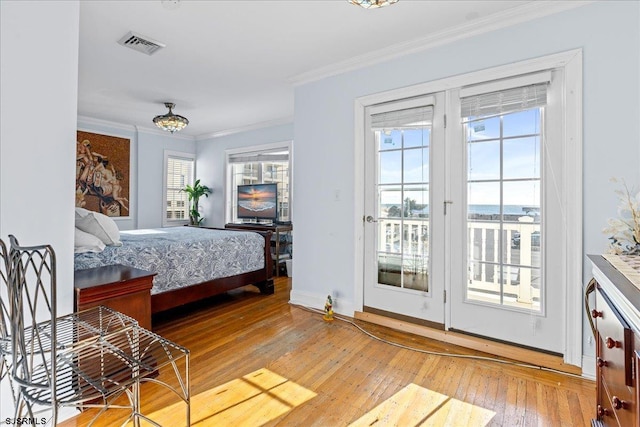 bedroom with access to outside, hardwood / wood-style flooring, an inviting chandelier, and ornamental molding