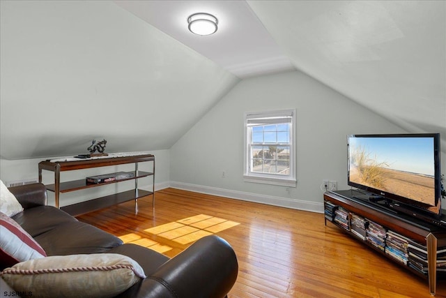 living room with light wood-type flooring and vaulted ceiling