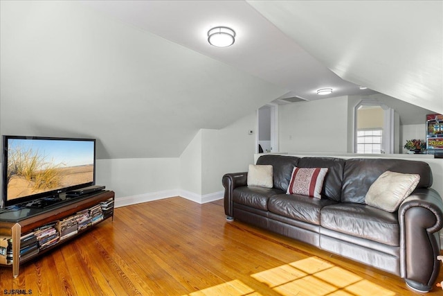 living room featuring hardwood / wood-style flooring and vaulted ceiling