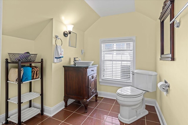 bathroom featuring tile patterned flooring, vanity, lofted ceiling, and toilet