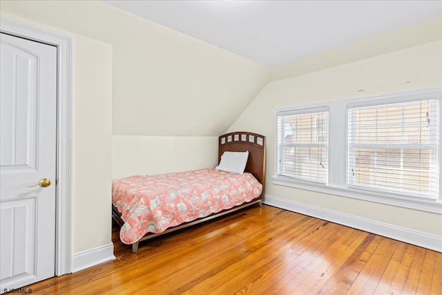 bedroom featuring wood-type flooring and vaulted ceiling