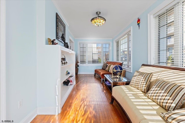 sitting room featuring wood-type flooring and ornamental molding