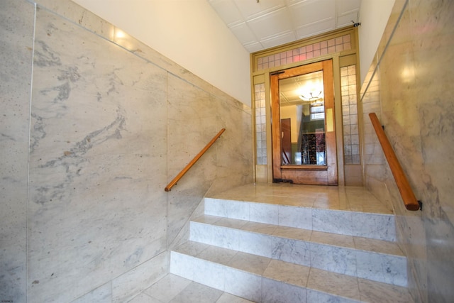 stairway featuring tile walls