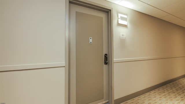 interior space with a paneled ceiling