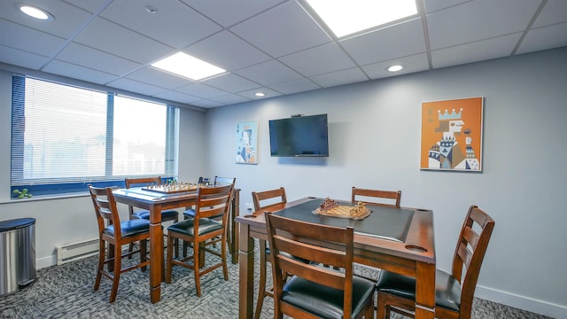 carpeted dining room featuring a drop ceiling and a baseboard radiator