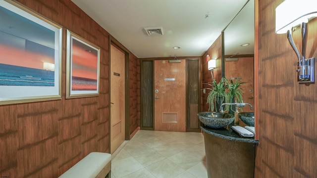 interior space featuring sink and wooden walls